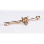 A 9ct yellow gold and diamond fox head bar brooch: the head set with two rose cut diamonds (5.1cm