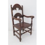 An oak open armchair in late 17th century style (probably 19th century): the two arched foliate