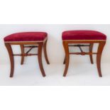 A pair of early 20th century mahogany stools in early 19th century style: red velour upholstered