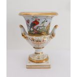 A modern reproduction two-handled porcelain urn of campana form and decorated with various exotic