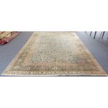 A large Persian Tabriz carpet: light green ground with stylised floral and foliate designs within