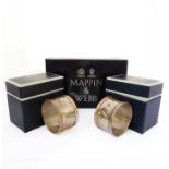 A pair of hallmarked silver circular napkin rings by Mappin & Webb in their original boxes.