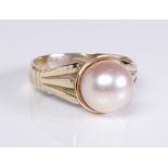 A 9ct yellow gold and cultured pearl ring: marked '9CT', the 9mm. pearl in a cup setting over