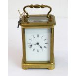 An early 20th century brass and glass-sided carriage clock: white-enamel dial with Roman numerals