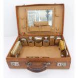 An early 20th century hand-stitched brown-leather vanity case embossed with LM initials beneath an