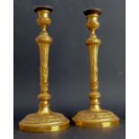 A pair of early 19th century French Empire period heavy gilt-bronze candlesticks of neoclassical