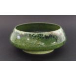 Ruskin Pottery - a small shallow high-fired footed bowl decorated in mottled green glaze, 'Ruskin