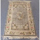 A small Chinese silk rug: central wreath against a silvered ground and borders with flowerheads (