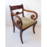 A Regency period mahogany armchair: the fluted concave figured top rail above a carved crest rail;
