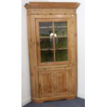 A late 18th century (with restorations) free-standing pine corner cupboard: the outset cornice above