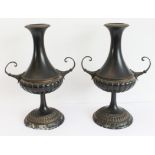 A pair of late 19th to early 20th century two-handled patinated (bronze?) vases on circular black