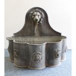 A solid lead fountain feature in classical style: the arched top with lion mask spout; the body with