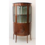 An early 20th century bow-fronted mahogany and boxwood-strung freestanding display cabinet: single