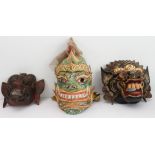 Two highly decorative carved and painted wooden masks (possibly Vietnamese or Cambodian) and a