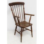 A late 19th to early 20th century lathe-back open armchair with shaped elm seat.