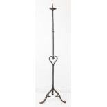 A large wrought iron pricket stick with unusual central heart motif and raised on tripod base (159cm