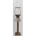 A late 19th/early 20th century brass lamp having facet-cut clear-glass reservoir and reeded column-