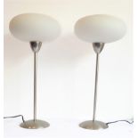 A pair of steel shafted table lamps with 'flying saucer-shaped' frosted glass shades