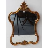 A modern reproduction gilt-framed mirror with acanthus style pediment and C-scrolls to the sides (60