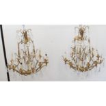A large and showy pair of gilt metal and cut-glass, 12 light chandeliers: varying tiers with