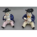 A pair of 19th century seated Staffordshire figures (as pots with removeable hats, minor damage) (