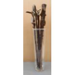 A modern glass stick or umbrella holder and nine walking sticks to include an early 20th century