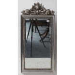 A silver-framed wall-hanging looking glass: hand-bevelled plate and foliate carved pediment (83 x