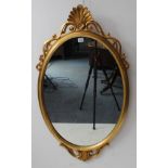 A modern gilt-framed oval looking glass with scallop-shell style pediment (96 cm highest x 57 cm