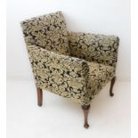 A 1920s (later upholstered) high armed club-style chair on stained wooden front legs (70 cm wide x