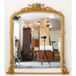 A large 19th century (later painted gold) overmantel mirror: ornate top pierced with C-scrolls;
