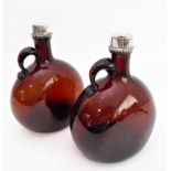 A pair of 19th century silver-mounted brown-glass flasks: the circular silver tops and neck ferrules