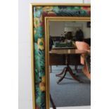 A floral framed wall-hanging mirror (74 x 43 cm).