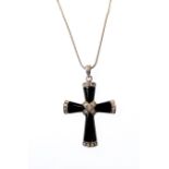 A silver-mounted black hardstone cruciform pendant set with hand-cut white stones and on a silver