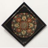 A late 19th to early 20th century needlework: circular design formed from a central flowerhead,