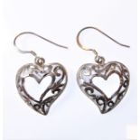 A pair of silver earrings modelled as pierced heart forms