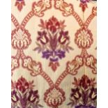 A pair of curtains with a woven terracotta and burgundy floral pattern on a heavy silk-effect