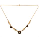 A 9 carat yellow gold (marked 9CT to the clasp) necklace, centrally set with a pearl and six hand-