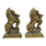 A good and unusual pair of brass and lead-weighted doorstops modelled as lions coward (34 cm high)