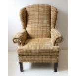 A modern armchair with check upholstery and dark wood square front legs (81 cm wide x 104 cm high)
