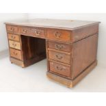 A late 19th to early 20th century mahogany pedestal desk: tooled inset leather top (distressed)
