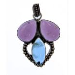 A silver pendant: the lower elliptical-shaped light blue stone with a beaded heart-shape and below