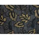 Two pairs of curtains in a striking woven fabric of black and gold patterned with leaves embroidered