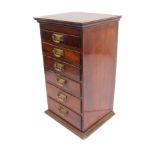 A late 19th century tabletop bank of mahogany/fruitwood (?) drawers: cleated slightly overhanging