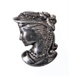 A heavy silver brooch modelled as a young maiden's head wearing a bonnet wearing a bow: she faces