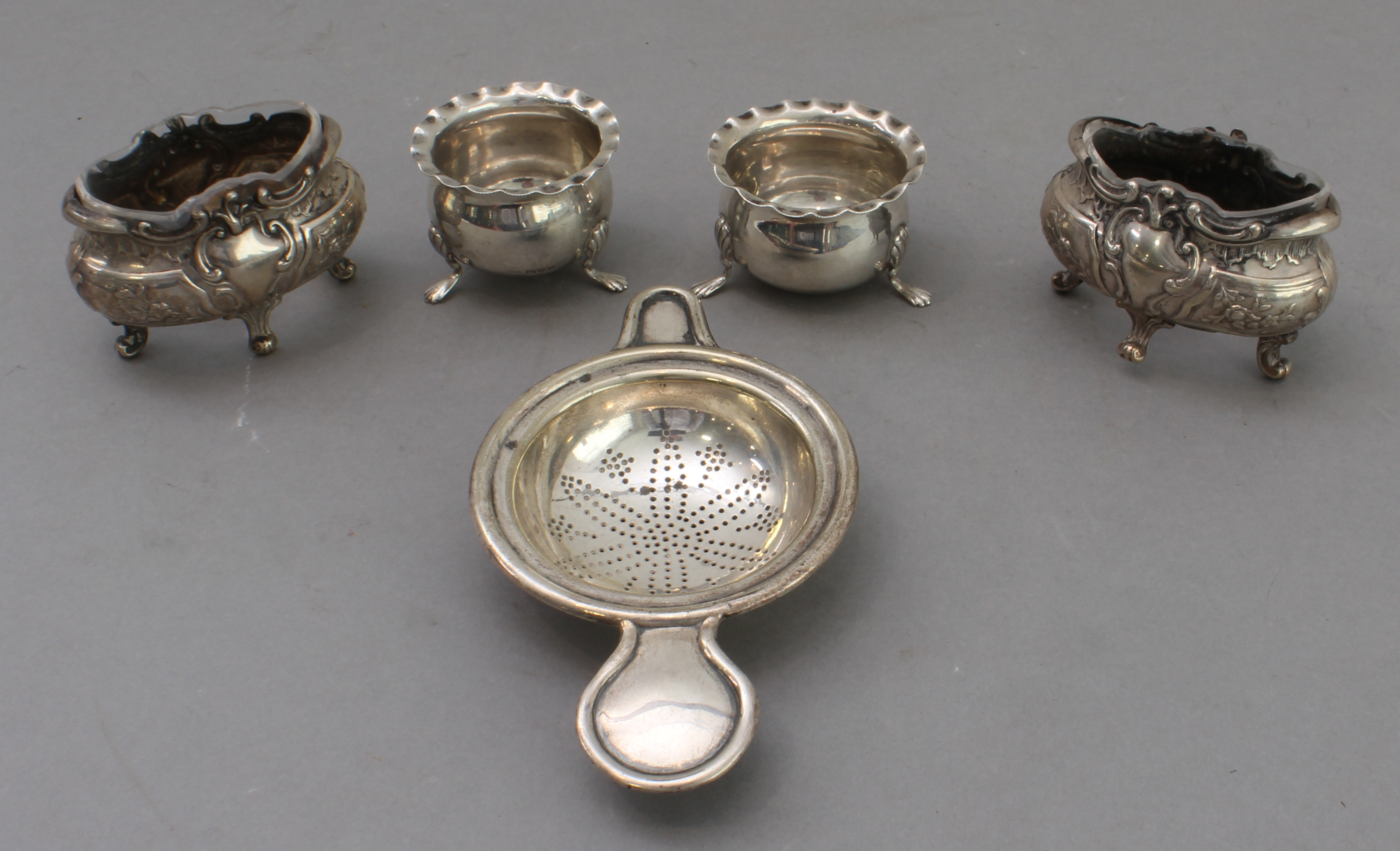 An assortment of silver comprising: 1. a continental silver strainer; 2. a pair of cauldron-shaped