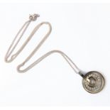 A silver pendant of concentric circle form: the inner moveable concentric circle mounted with