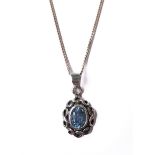 An oval silver pendant: set with vertical hand-cut blue oval stone surrounded by a pierced Celtic-