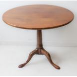 A large 18th century circular-topped mahogany tilt-top table: turned gun-barrel-style stem and on