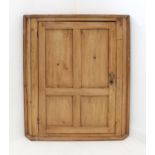 A late 18th to early 19th century hanging pine corner cupboard; single panelled door enclosing