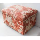 An upholstered ottoman decorated in cream with exotic birds on leafy branches and flowers against